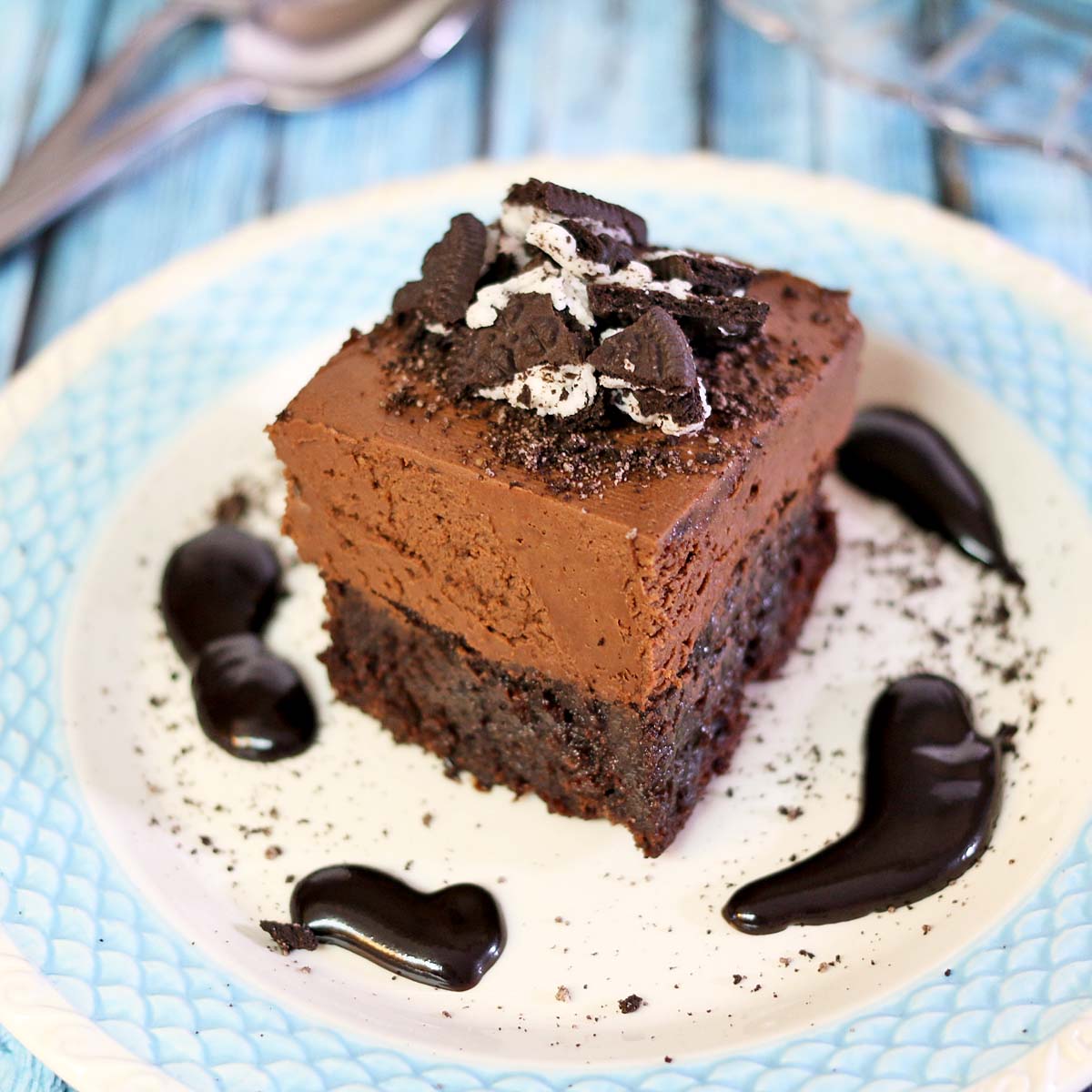 A piece of chocolate cake on a plate, with Cheesecake and Gooey butter cake